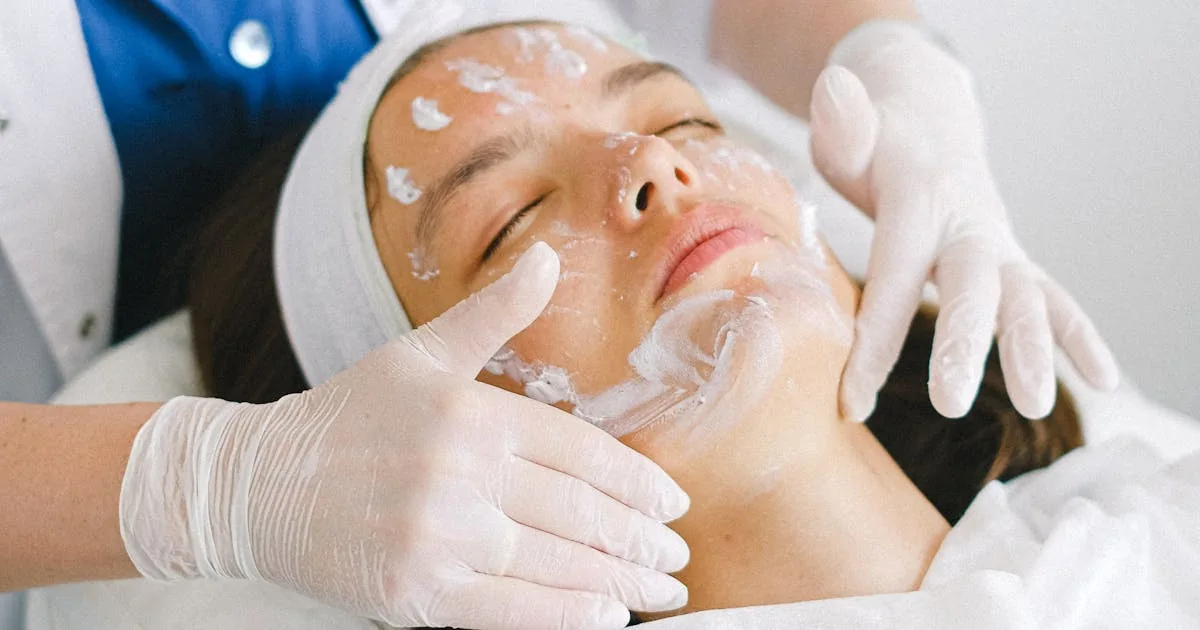 Cosmetologista aplicando máscara facial em cliente